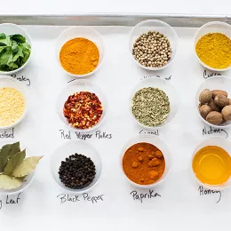 A selection of spices in cups on a baking sheet