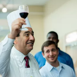 A man raises a wine glass in a toast at a special event at ICE