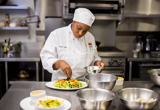 A Plant-Based Culinary Arts student prepares a colorful salad