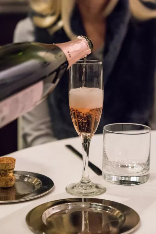Bubbly rose is poured into a champagne flute