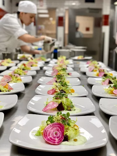 A Culinary Arts student garnishes dishes on banquet day