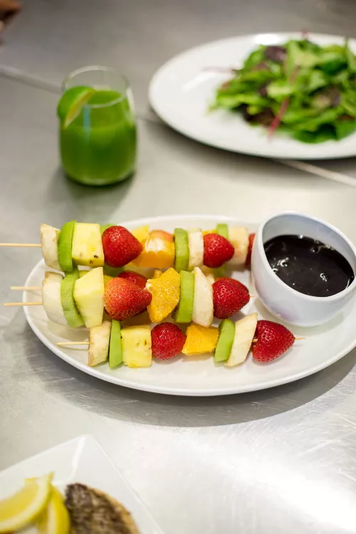 Fruit kebabs, green juice and a green salad