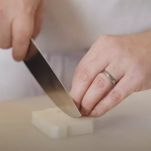 Chef Chris Arturo uses a knife to cut a turnip