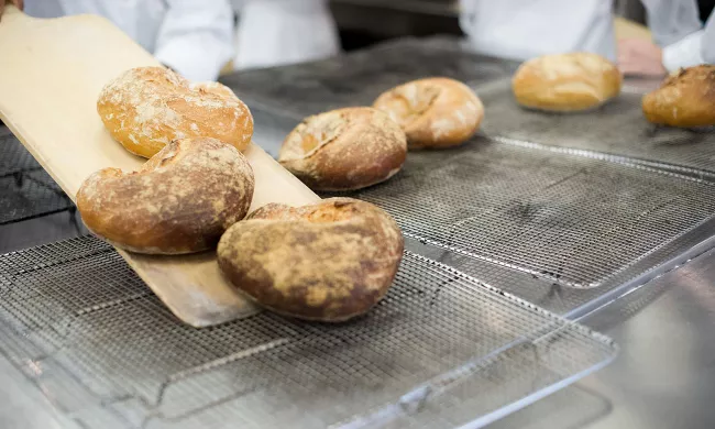 Freshly baked breads are removed from the oven to cool at the Institute of Culinary Education