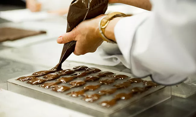 Chocolate being piped into molds.